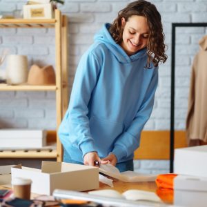 Close-up of preparing a parcel on the table. Woman online store, small business owner, entrepreneur.