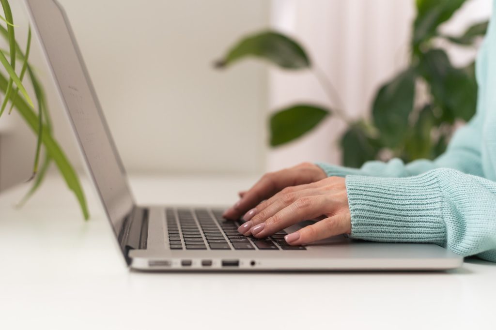 woman using laptop, searching web, browsing information, having workplace at home.