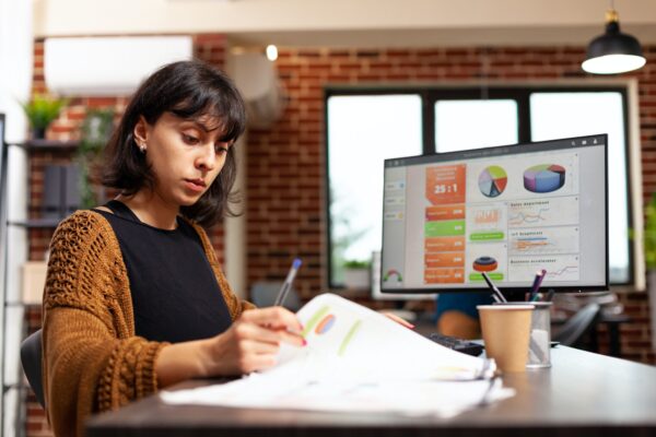 Businesswoman analyzing marketing graph working at company strategy in startup office